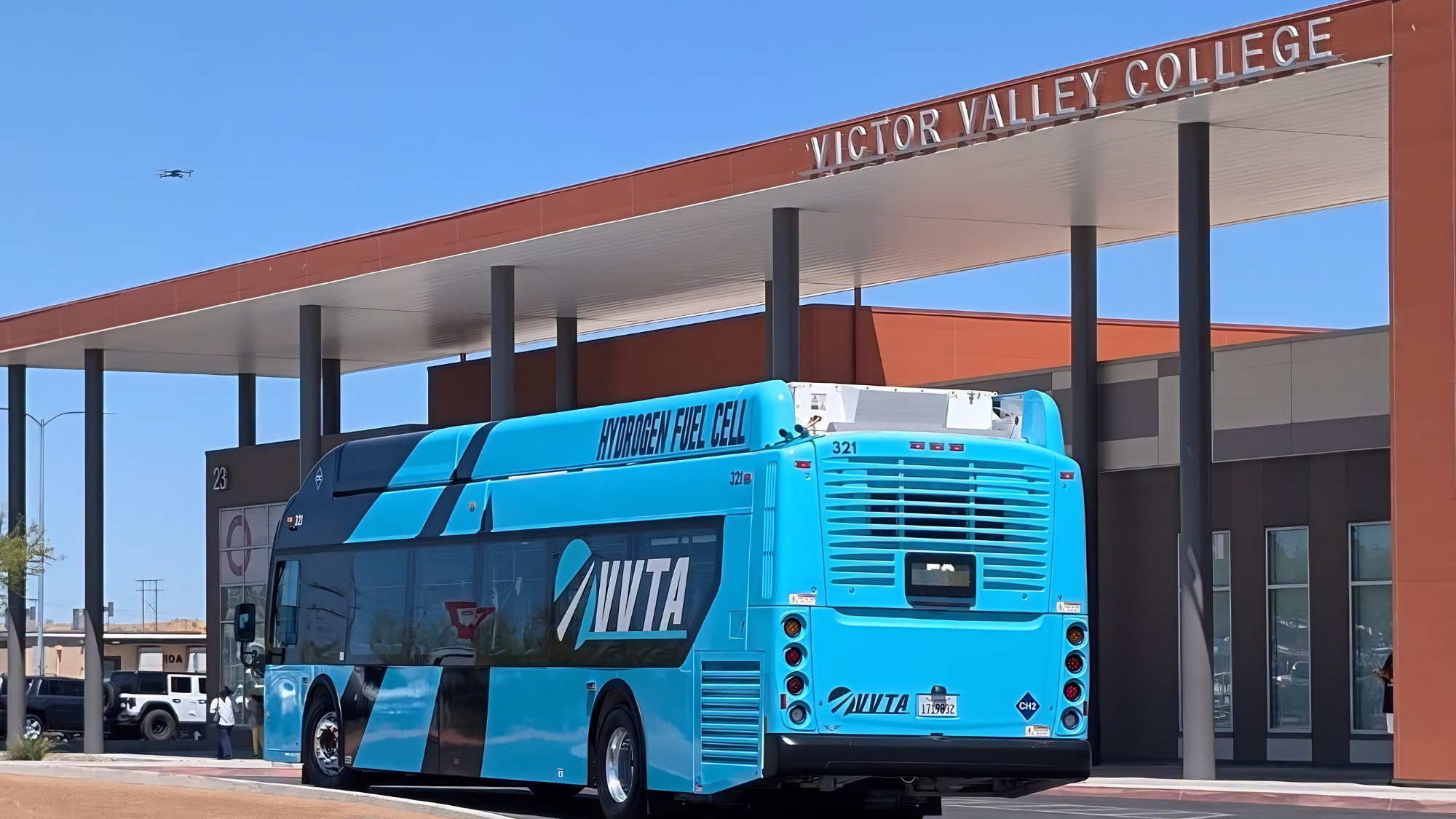 VVCBus A blue Victor Valley Transit Authority (VVTA) hydrogen fuel cell bus is parked outside the Victor Valley College campus beneath the main entrance canopy.